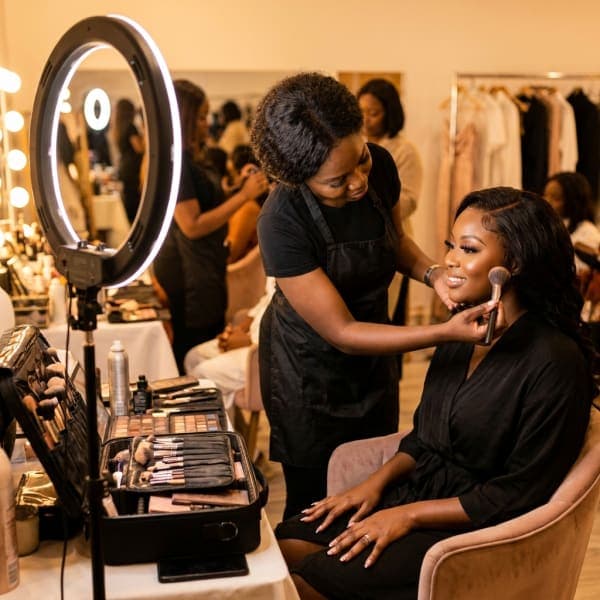 Makeup artist finishing a client’s glam in an event getting-ready suite
